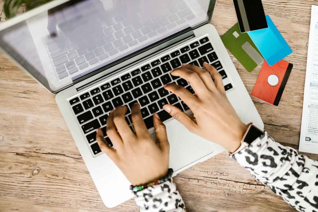 Image of someone using a laptop and credit cards to make purchases online.